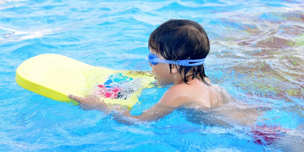 Toddler learning to swim in pool
