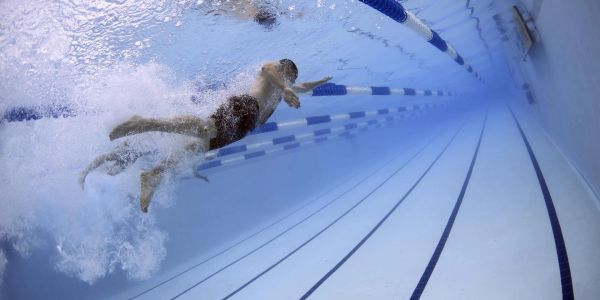 Student swimming with Coach Jared
