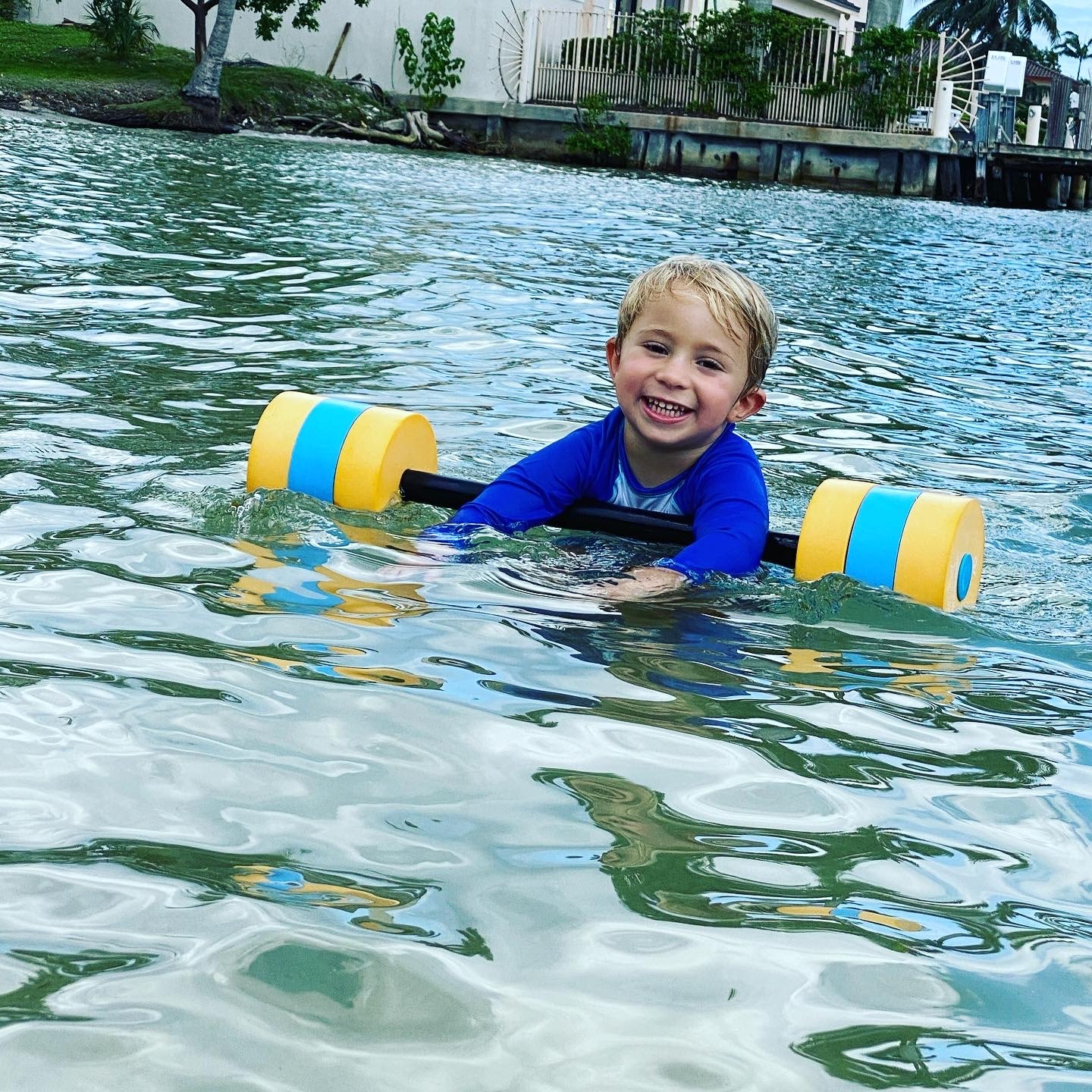 Toddler learning to swim in pool